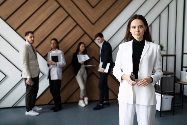 Office manager against the background of employees waiting for an interview in the office