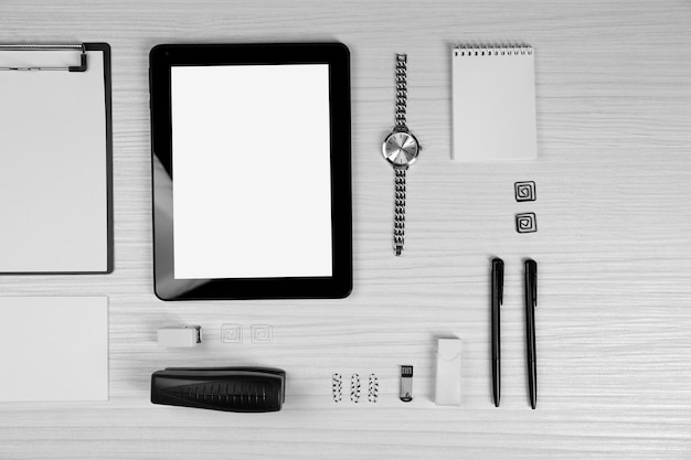 Office set with sheets of paper tablet and stationery on light wooden background