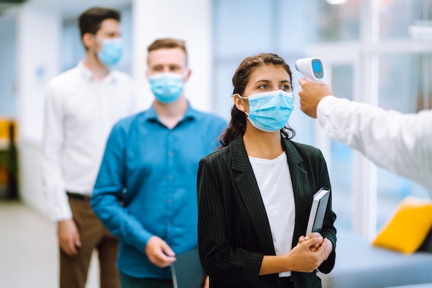 Office staff undergo temperature screening at the entrance. Business. Covid-19.