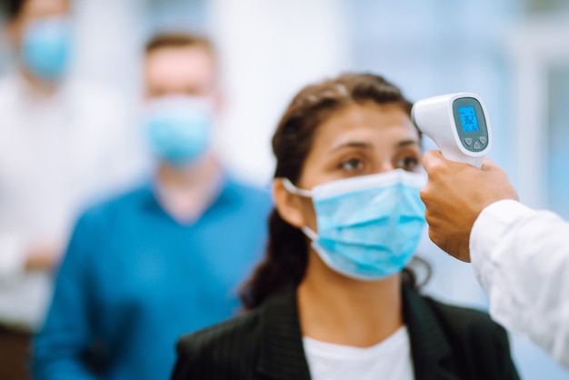 Office staff undergo temperature screening at the entrance. Business. Covid-19.