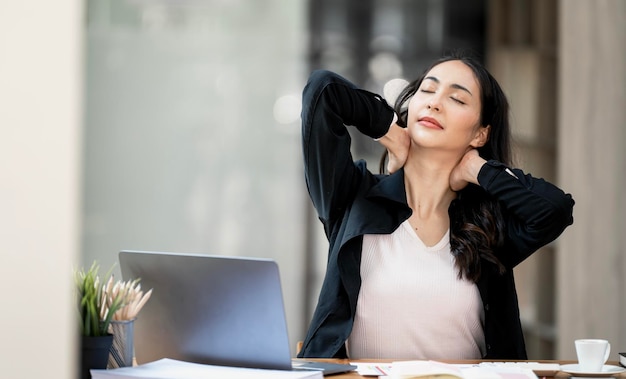 Office syndrome concept Beautiful asian businesswoman feeling pain in neck after working on computer laptop for a long time