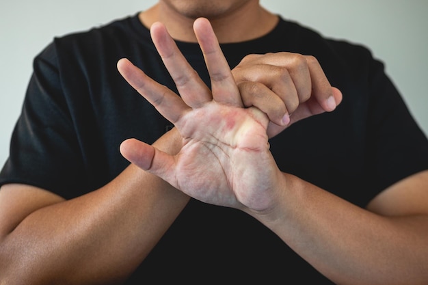 Office syndrome concept Little Finger is massaged and stretched after working Close up shot isolate on blue background Forehand view