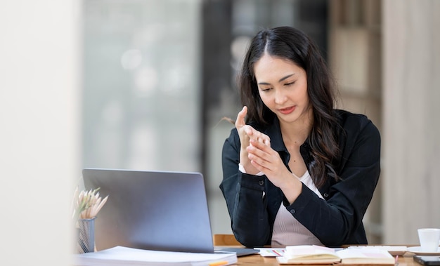 Office syndrome hand pain business woman with wrist pain Woman holding her wrist pain from using computer