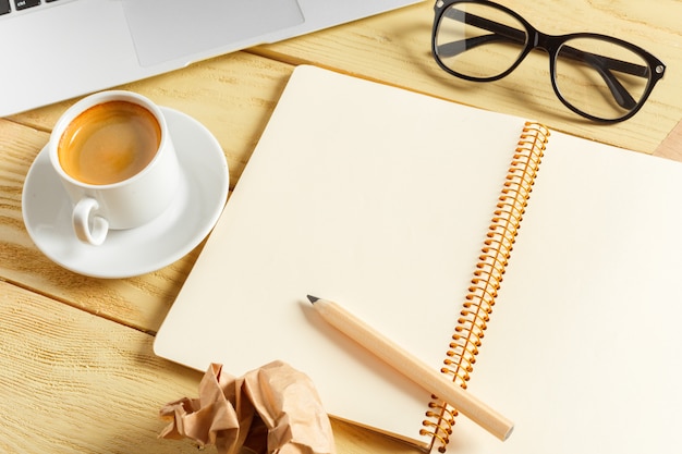 Office table background with coffee cup, pencils and computer keyboard. Business workplace or workspace concept.