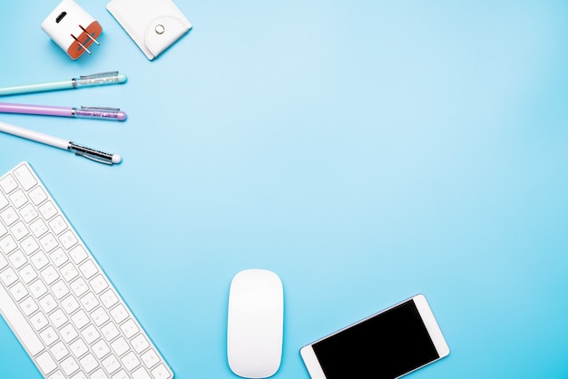 Office table with computer keyboard, mouse, smartphone and pen