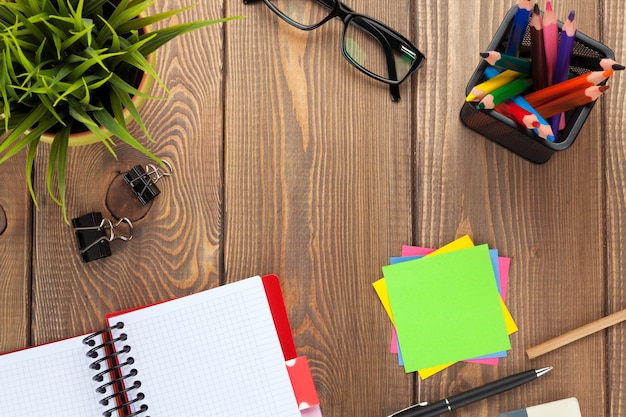 Office table with flower blank notepad and colorful pencils