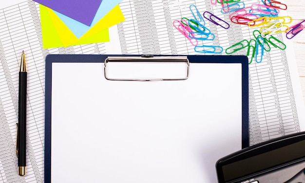 Office table with pen calculator colored stickers and paper clips and blank tablet with space to insert text business concept