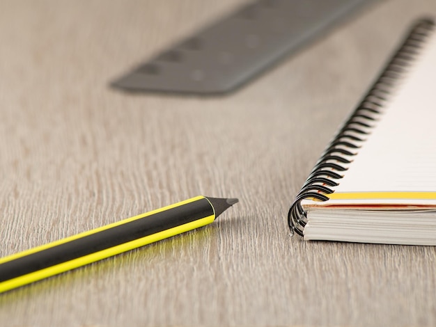 Office theme Pencil ruler and notepad on a gray office table closeup