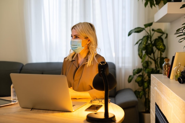 In the office. woman in a facial mask, the disinfector stands next to the table