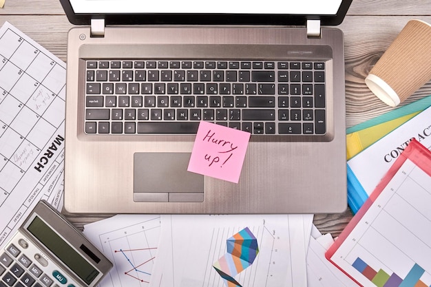 Office work desk with laptop and calculator