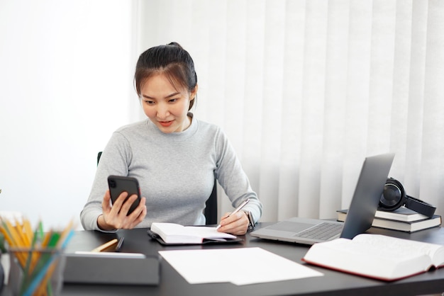 Office work a female officer using a mobile phone to check meeting agenda for tomorrow