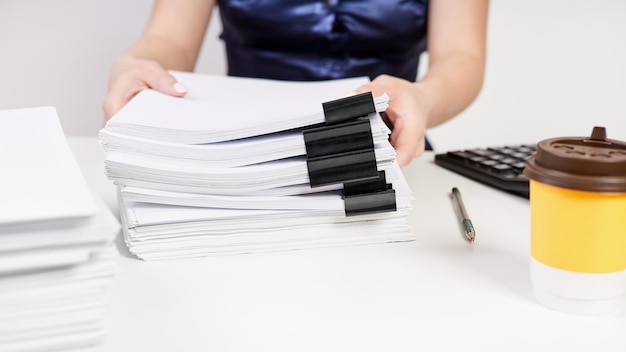 An office worker moves a stack of papers fastened with Binder Clips