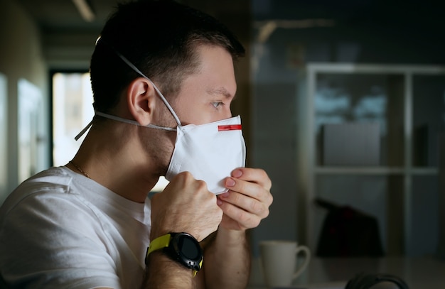 Office worker putting on a medical mask