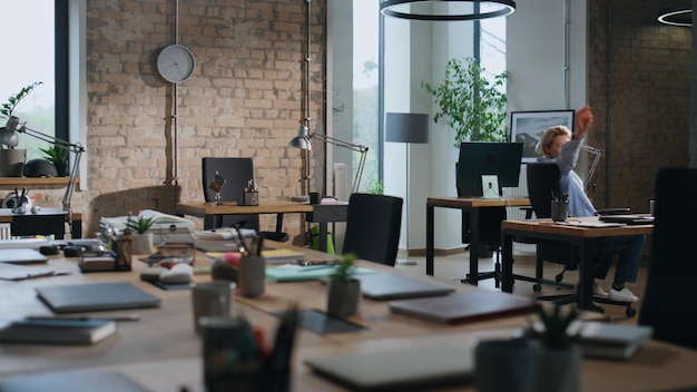 Office worker riding chair between tables in empty office lady having fun alone