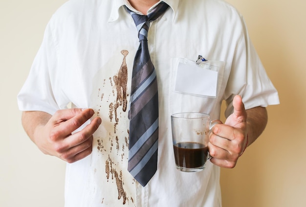 Office worker spills coffee on white shirt. Occupational burnout. Manager with mug in hands. Stressful job.