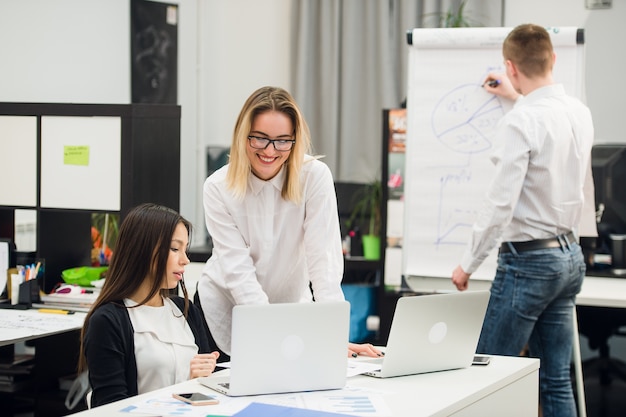 Office workers having a conversation while colleague draws business strategy