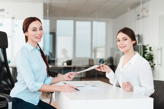 Office workers signing documents and smiling