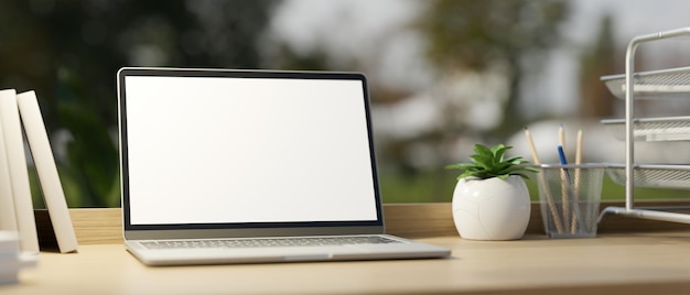 Office working desk with laptop computer white screen mockup and office supplies