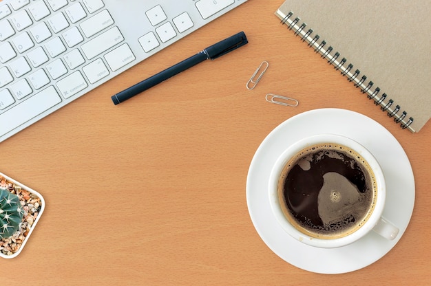 Photo office workplace with keyboard notepad mouse coffee of cup on wooden table. over light