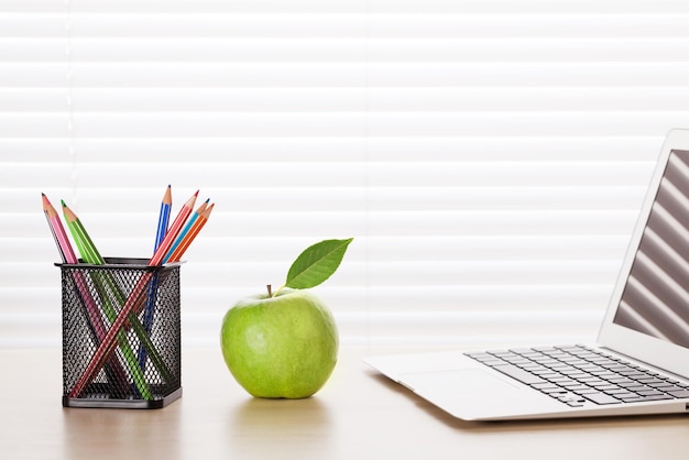 Office workplace with laptop apple and pencils