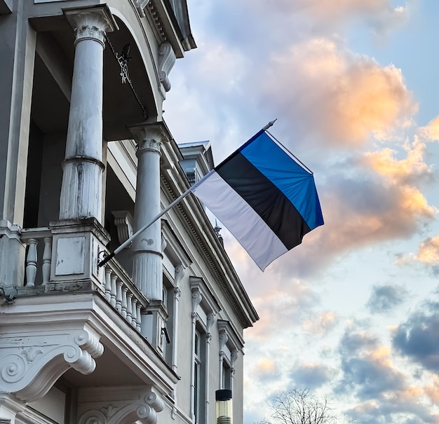 The official state symbol of estonia is a flag with a blue black and white stripe against a blue sky