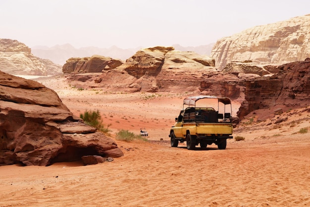 Offroad travel adventures safari jeep car in Wadi Rum desert Jordan Middle East known as The Valley of the Moon Red sands sky with haze Designation as a UNESCO World Heritage Site