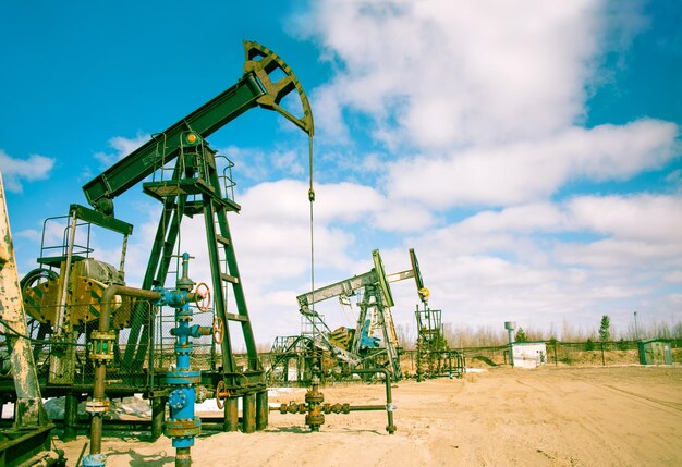 Oil and gas industry. Pump jack on a sky background. Toned.