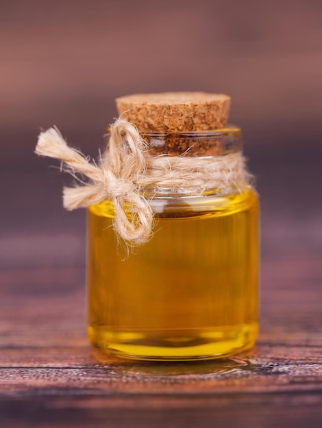 Oil in a glass jar on wooden background For cosmetic and beauty products