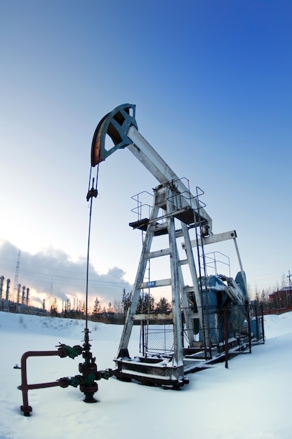 oil pump on  background of  industrial landscape and winter sky in  smoke