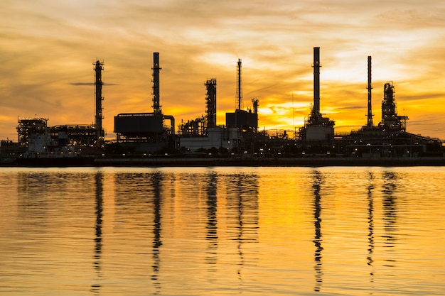 Oil refinery factory in silhouette and sunrise sky