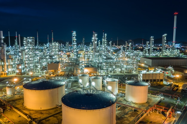 Oil refinery and gas petrochemical industry with storage tanks steel  pipeline area at twilight aerial view