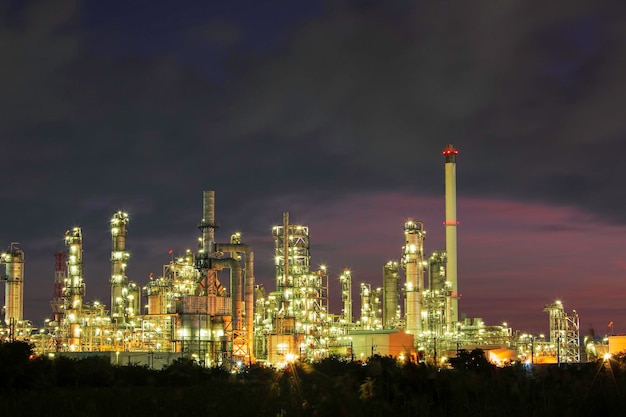 Oil refinery and plant and tower column of Petrochemistry industry in pipeline oil and gas industry with cloud slowing red sky the morning background