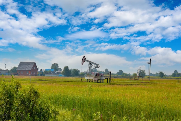 An oil rocking chair in a field next to residential buildings in Russia.