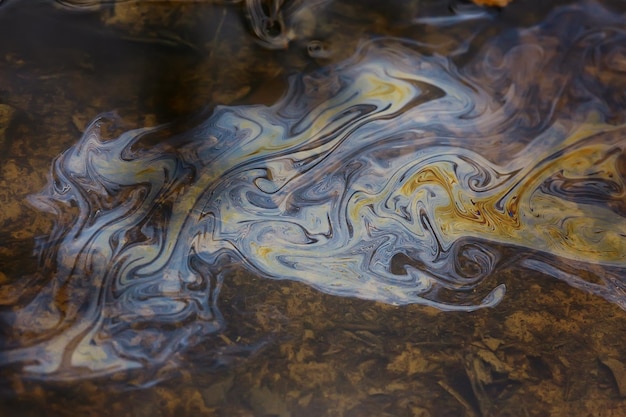 oil spills on puddle background, abstract gasoline nature pollution concept