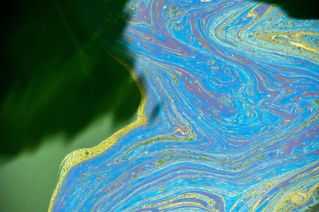 Oil spreading on sea surface Aerial top down view like a abstract painting with the rainbowcolored oil spill pattern