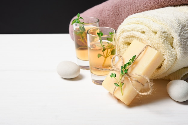 Oil, towel, soap and stones on a white table