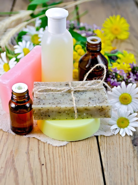 Oil with lotion and soap with wildflowers on the board