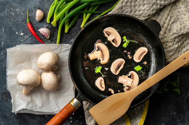 Oiled hot saucepan filled with chopped champignons, mushroom cookings