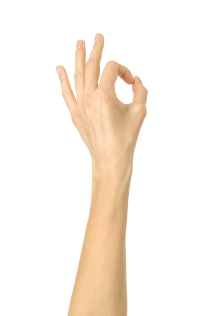 Ok sign. Woman hand with french manicure gesturing isolated on white wall. Part of series