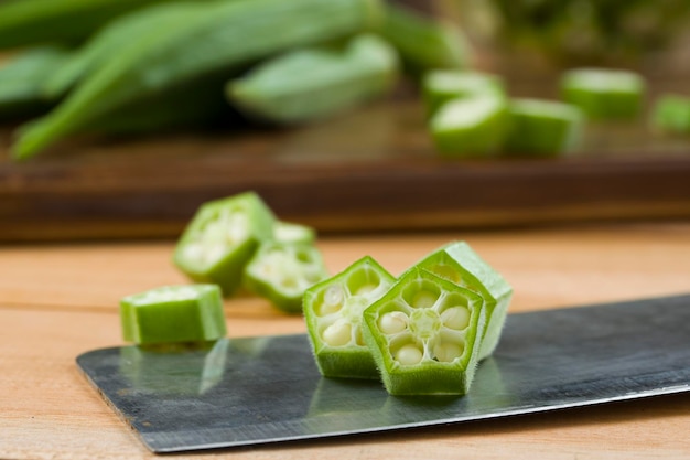 Okra or Ladys finger or Bhindi closeup image of fresh green vegetable sliced rings arranged  on  the base with some okra placed behind it selective focus