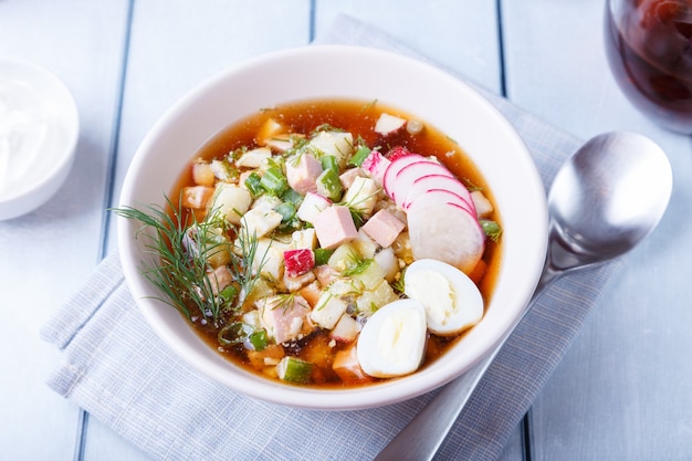 Okroshka with kvass and sausage. Traditional classic cold Russian soup. Close-up.