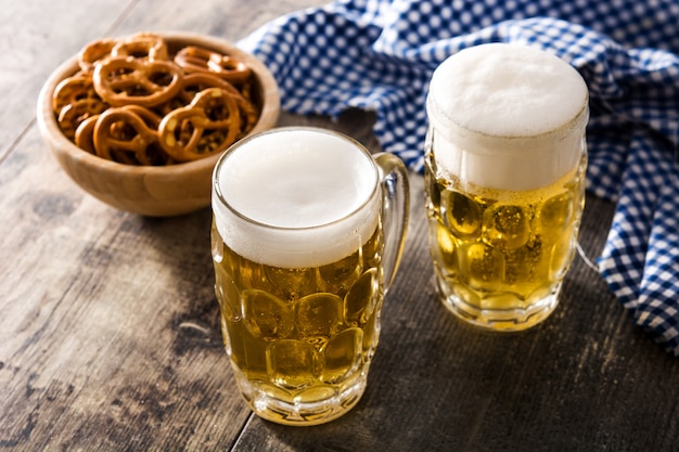 Oktoberfest beer and pretzel on wooden table.