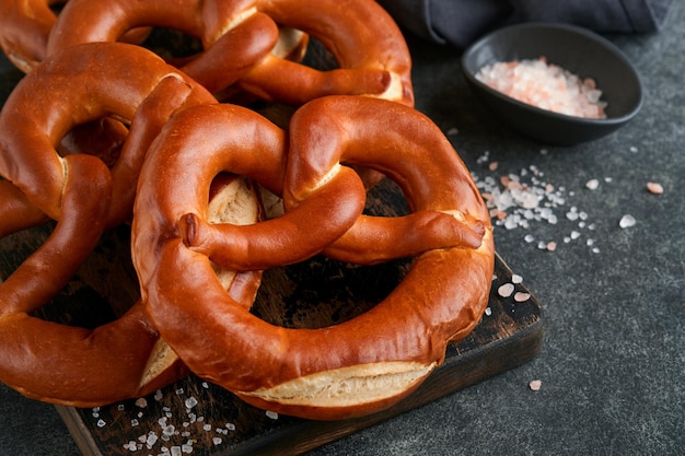 Oktoberfest concept card Traditional Bavarian pretzels with beer bottle mug on old dark black rustic background Perfect for Octoberfest Oktoberfest food menu