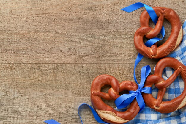 Oktoberfest concept card Traditional Bavarian pretzels with beer bottle mug on old rustic wooden background Perfect for Octoberfest Oktoberfest food menu Top view Mock up