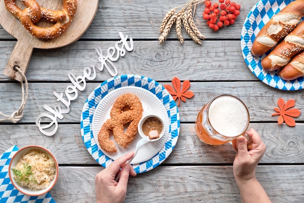 Oktoberfest traditional food and beer, flat lay on wooden table