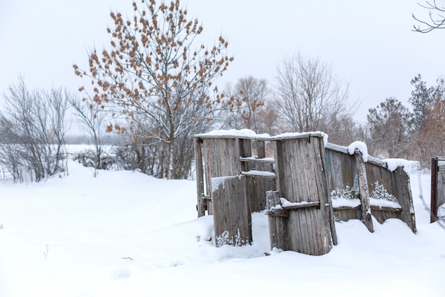 Old abandoned building from boards in the winter in the field