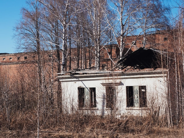 An old abandoned factory building in early autumn postapocalyptic background Collapsing buildings