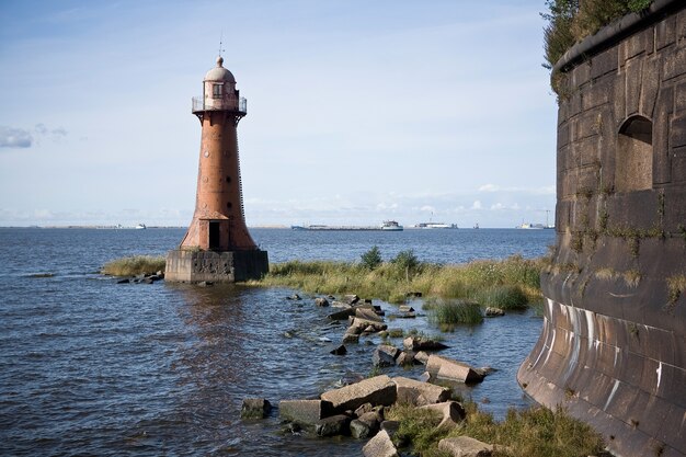 Old abandoned lighthouse near the shore on a sunny day