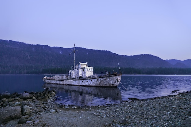 Old abandoned ship on coast Lake Teletskoye Altai Republic Siberia Russia Blue sky and