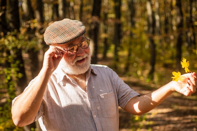 Old age is joy Old age pensioner enjoy autumn nature Old man collect yellow leaves Old person with grey beard hair Pension and retirement Leisure and lifestyle Adventure awaits